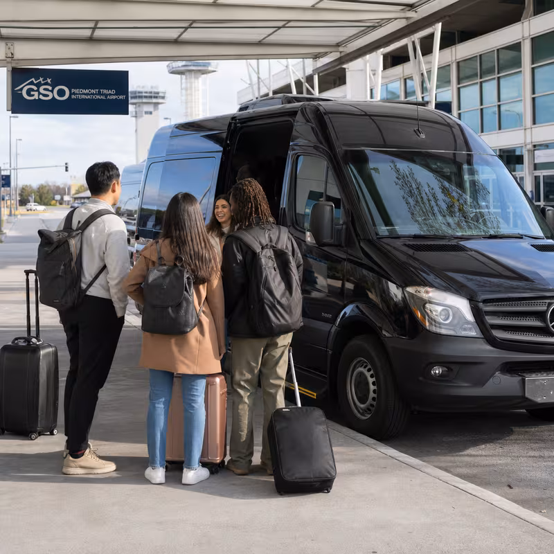 Group boarding a white charter bus for Airport Transportation transportation in Greensboro