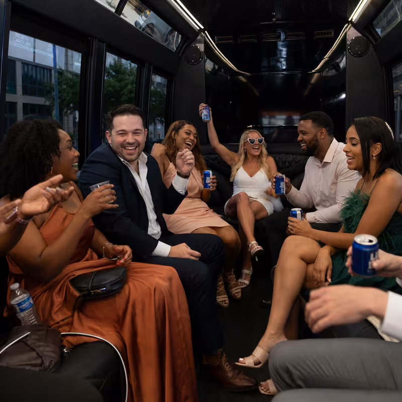 Party bus interior with wraparound leather seating and LED lighting in Greensboro