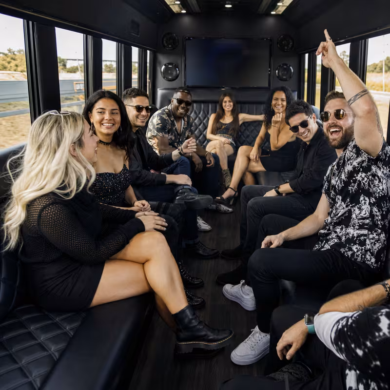 Group boarding a white charter bus for Concert Transportation transportation in Greensboro