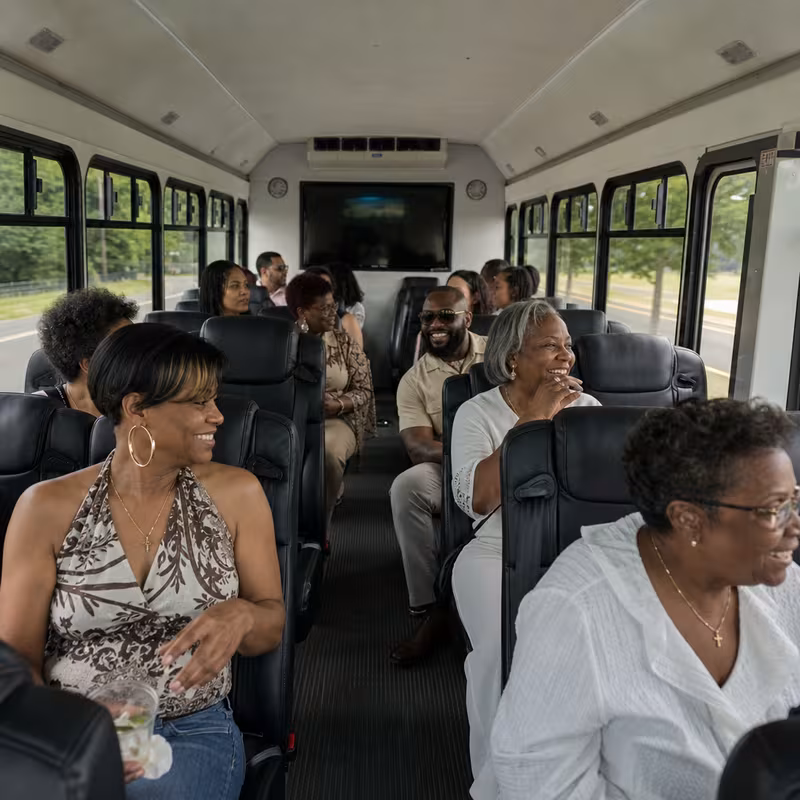 Group boarding a white charter bus for Private Event Transportation transportation in Greensboro