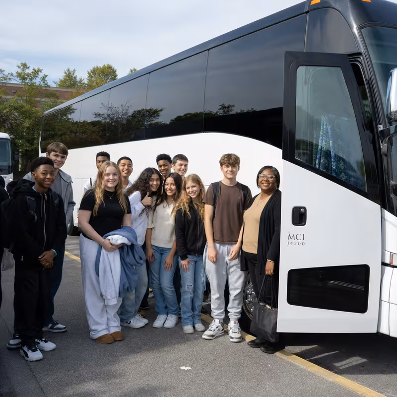 Passengers loading luggage while boarding an Greensboro group shuttle